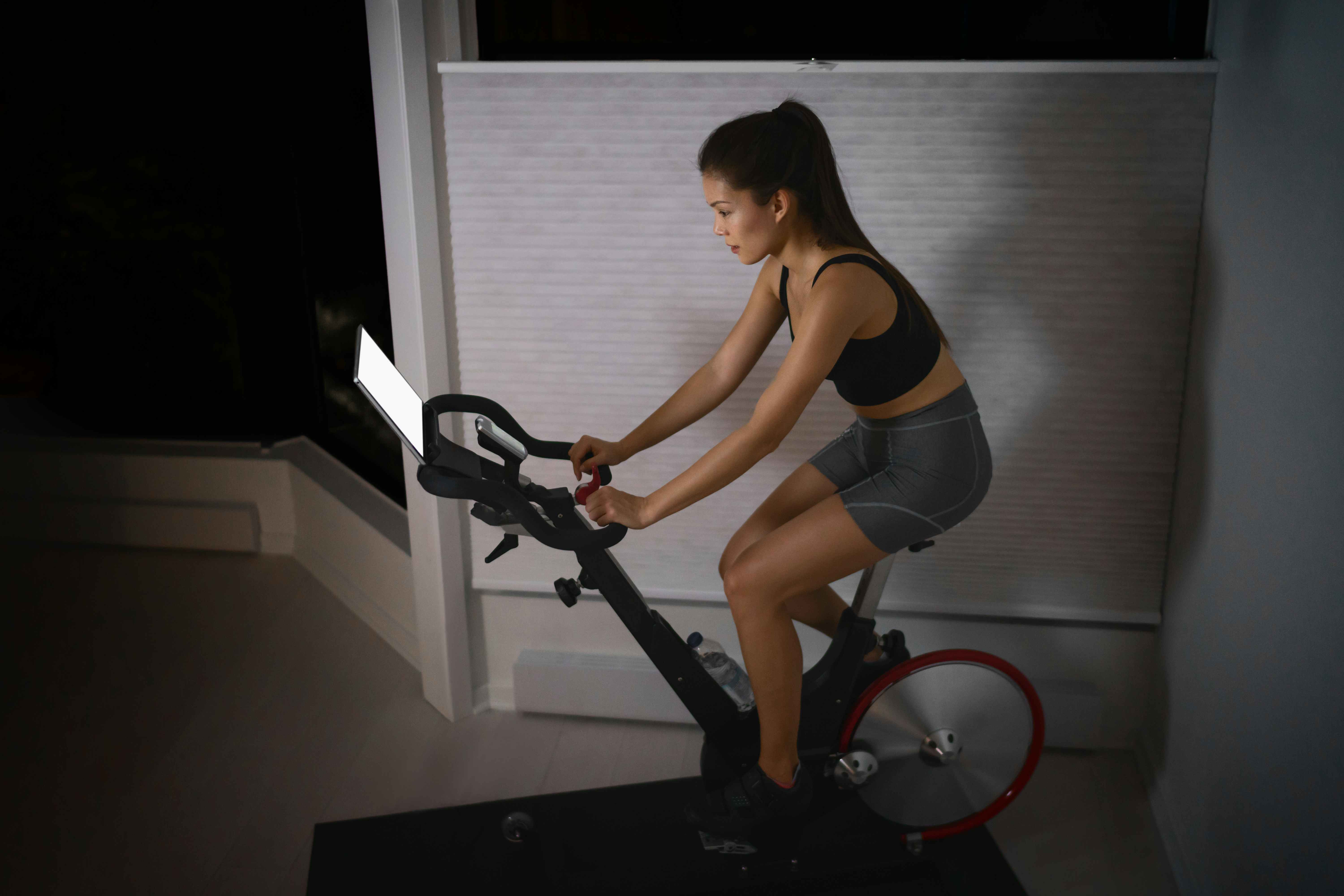 A woman on a stationary bike with a screen