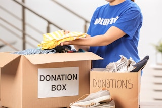 woman placing clothes in a donation box