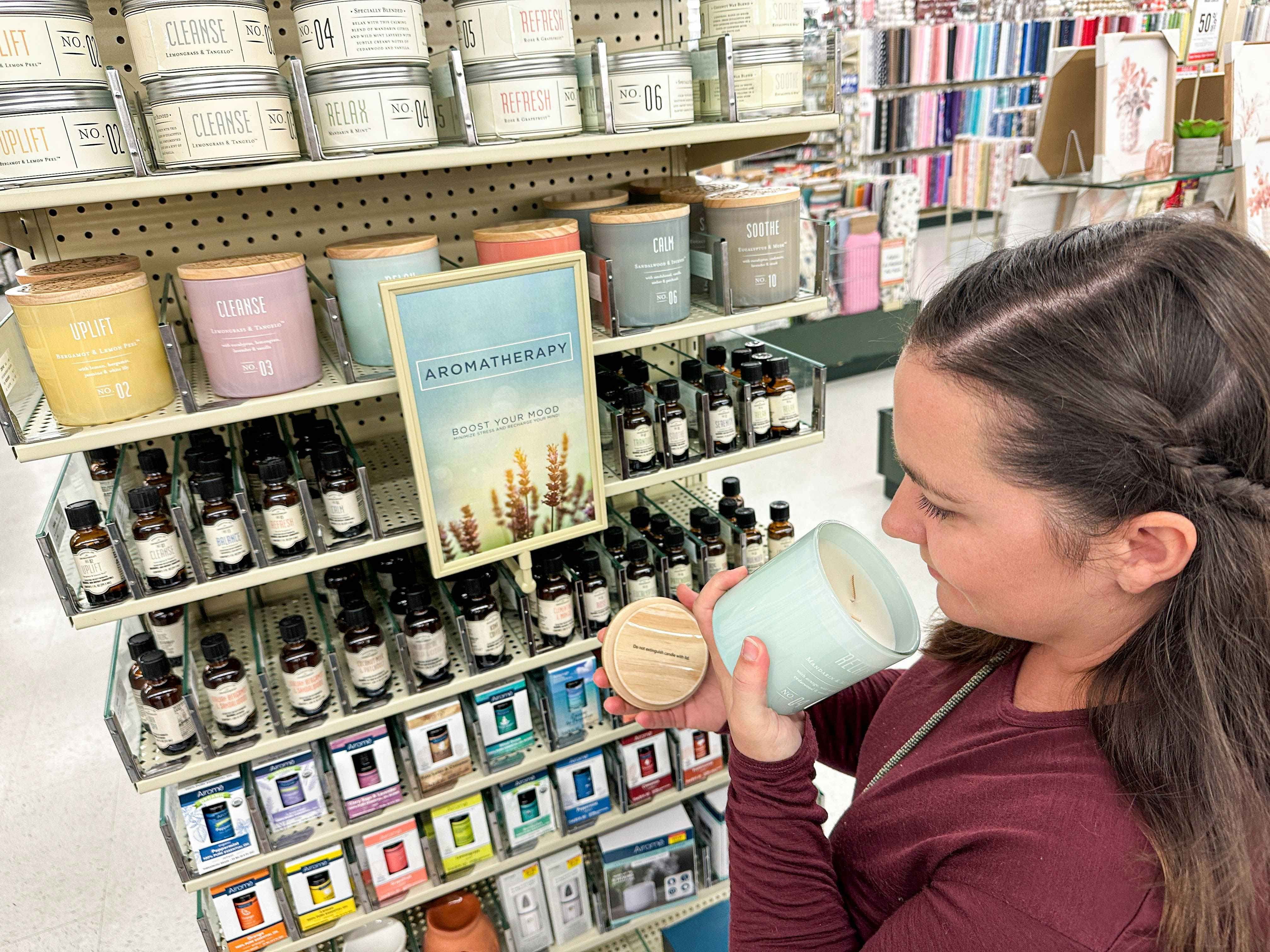 a woman smelling a candle in hobby lobby 