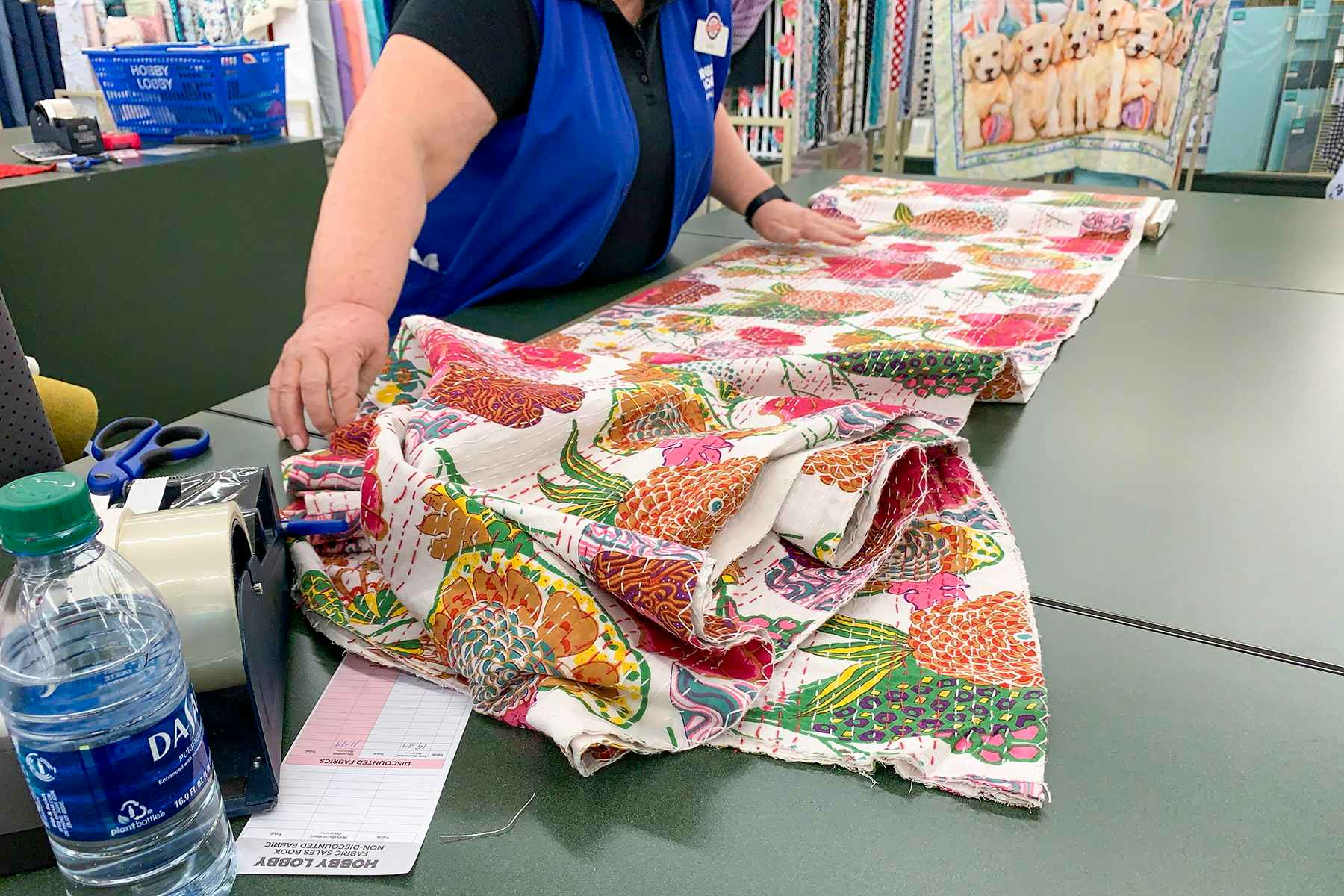 A Hobby Lobby employee cutting fabric.