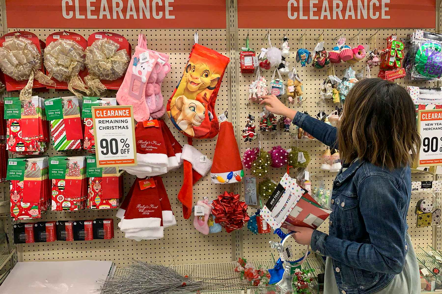 A woman shopping in the Hobby Lobby Christmas clearance section.