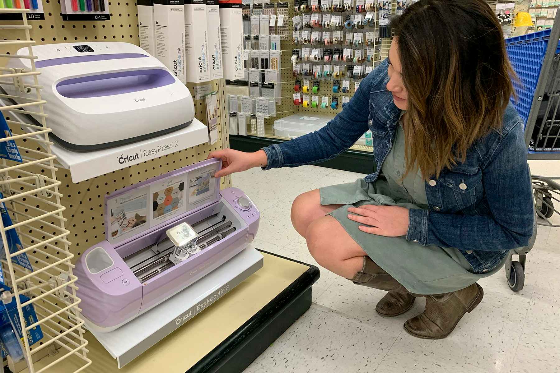 A woman looking at a Cricut Explore Air 2 on display in Hobby Lobby