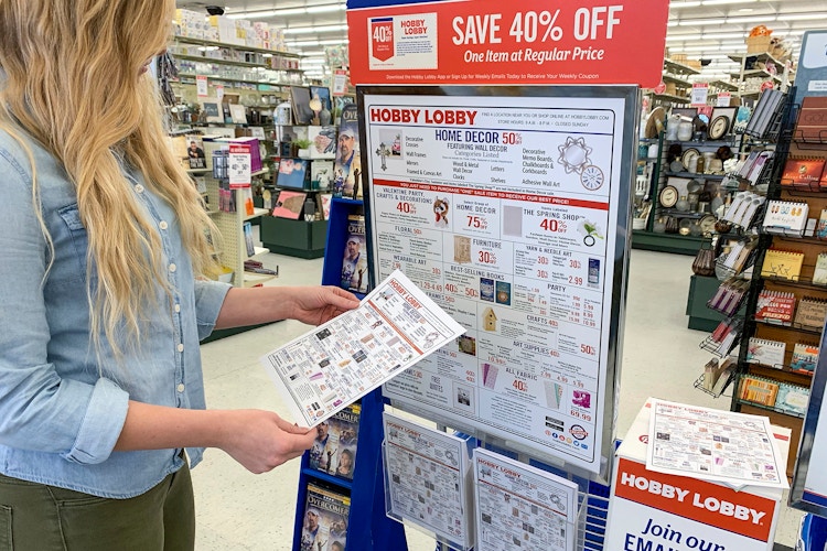 A woman looking at the sales schedule flyer.