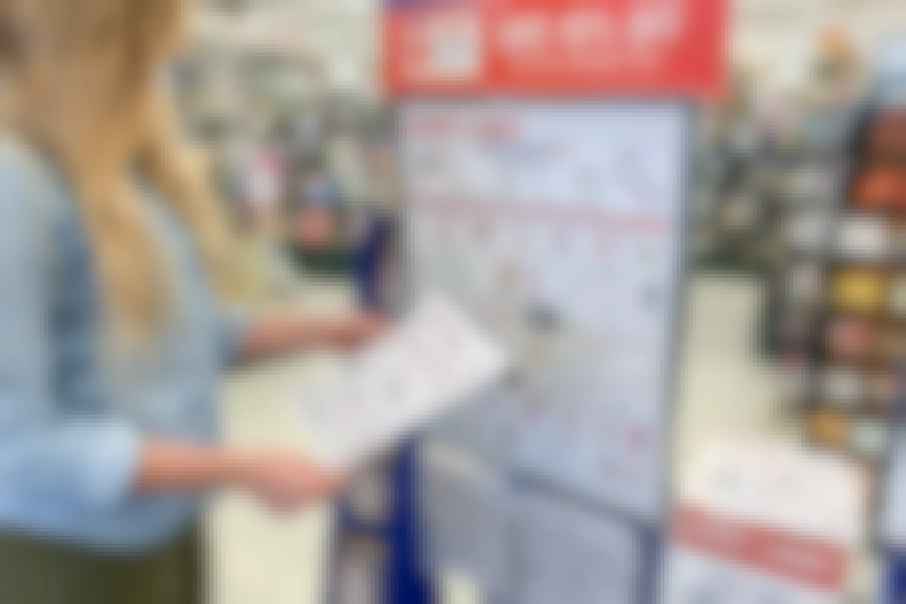 A woman looking at the sales schedule flyer.