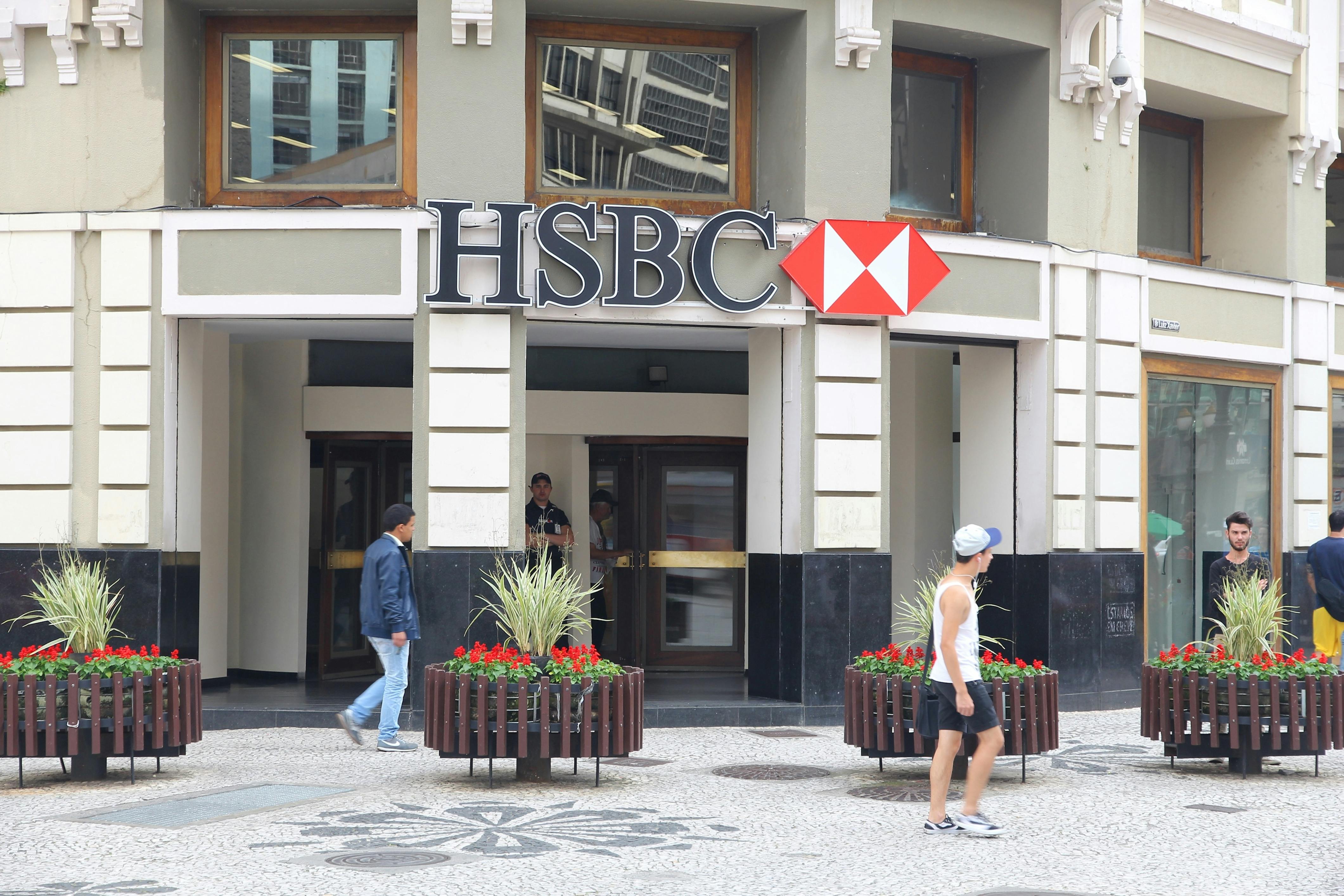 HSBC bank store front with people waking by