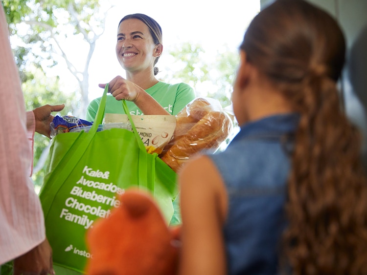 woman from instacart delivers groceries to door