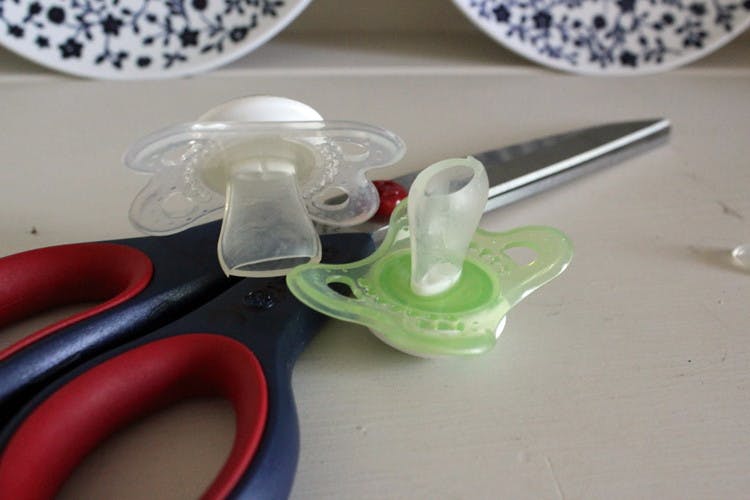 Wean baby off a pacifier by cutting a small piece off the nipple every time he or she uses it.