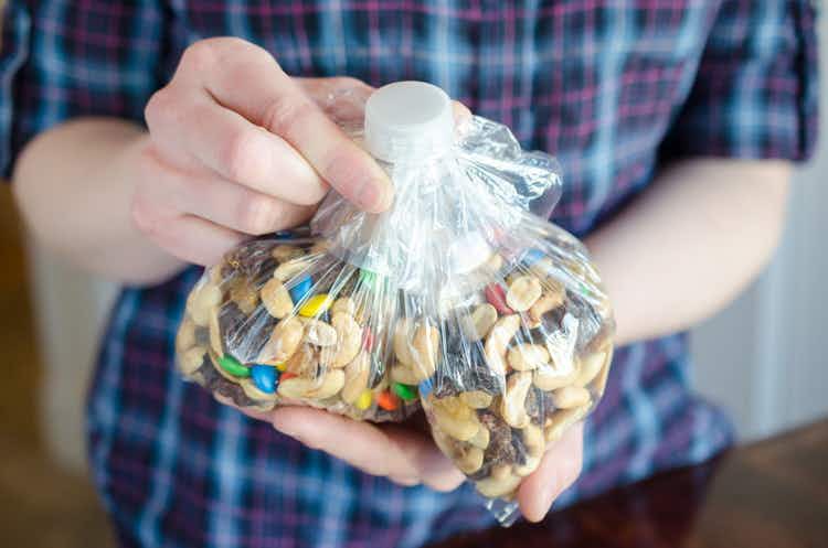 A person holding a bag of trail mix.