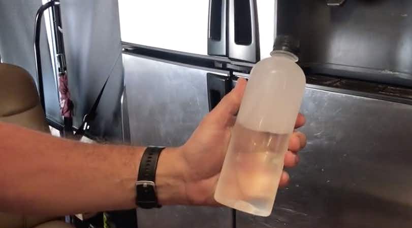 hand holds half frozen bottle of water
