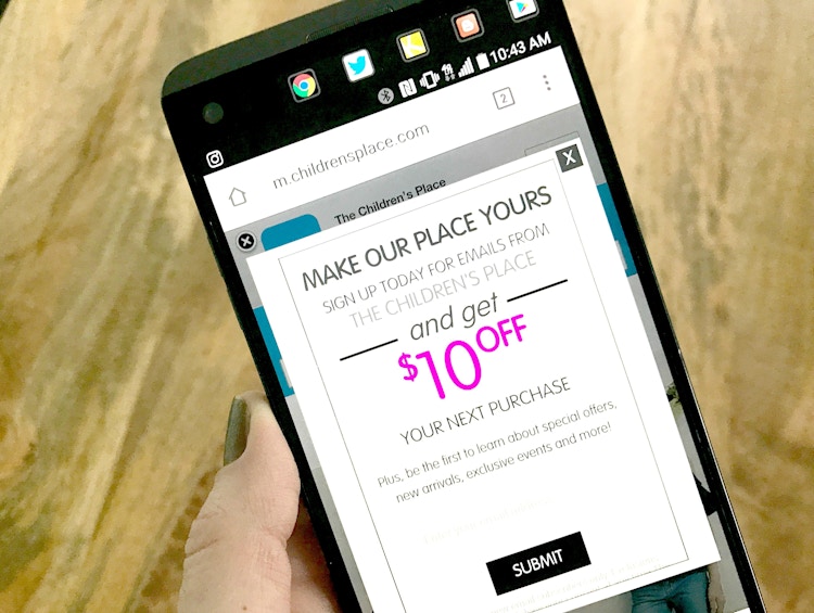 Someone looking on their phone in their email for a coupon to The Children's Place