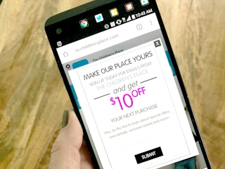Someone looking on their phone in their email for a coupon to The Children's Place
