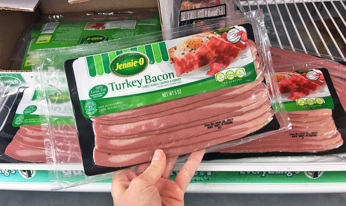 A person holding a package of Jenni-O bacon.
