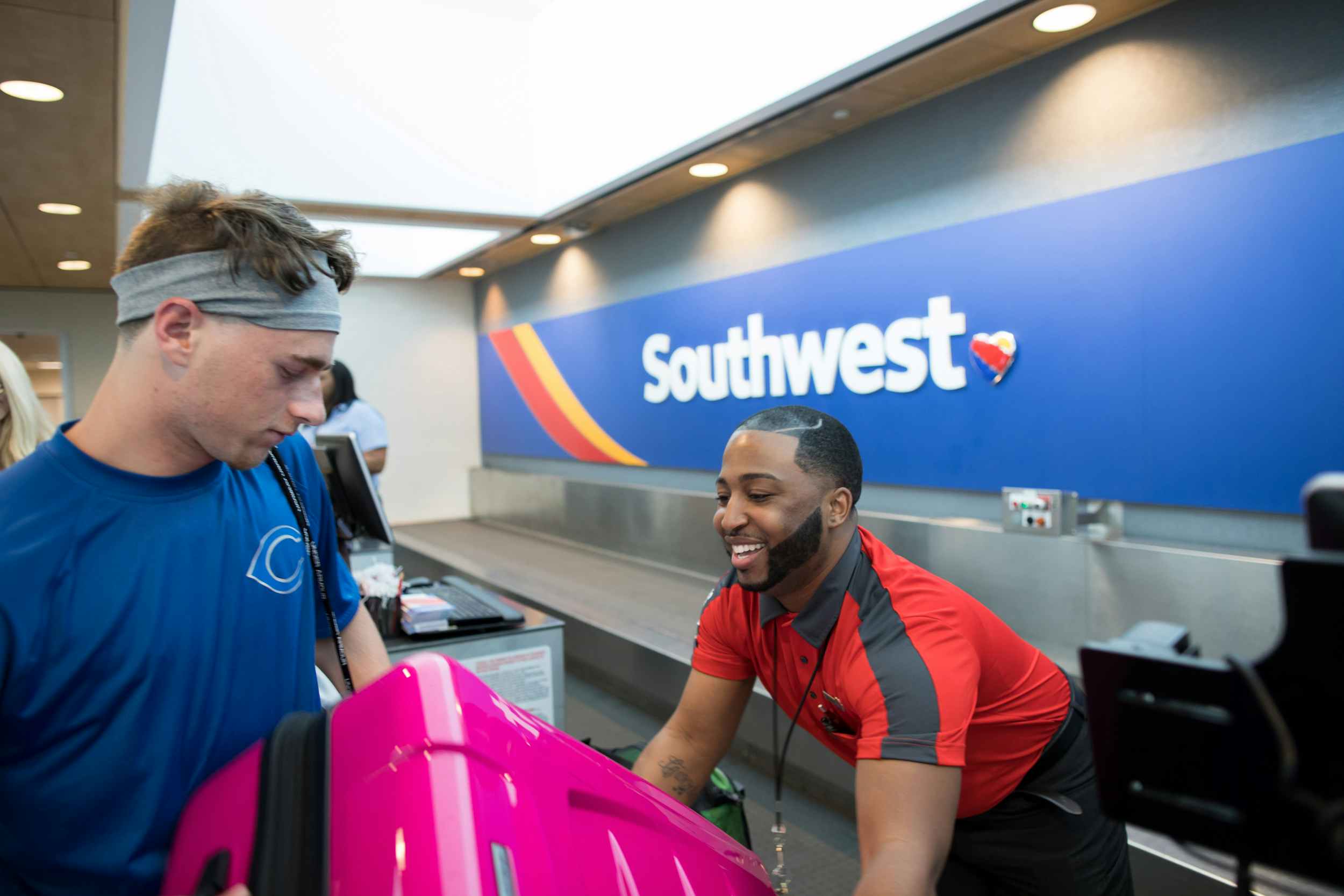 southwest employee at check-in gate taking luggage from passenger