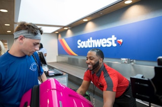 southwest employee at check-in gate taking luggage from passenger