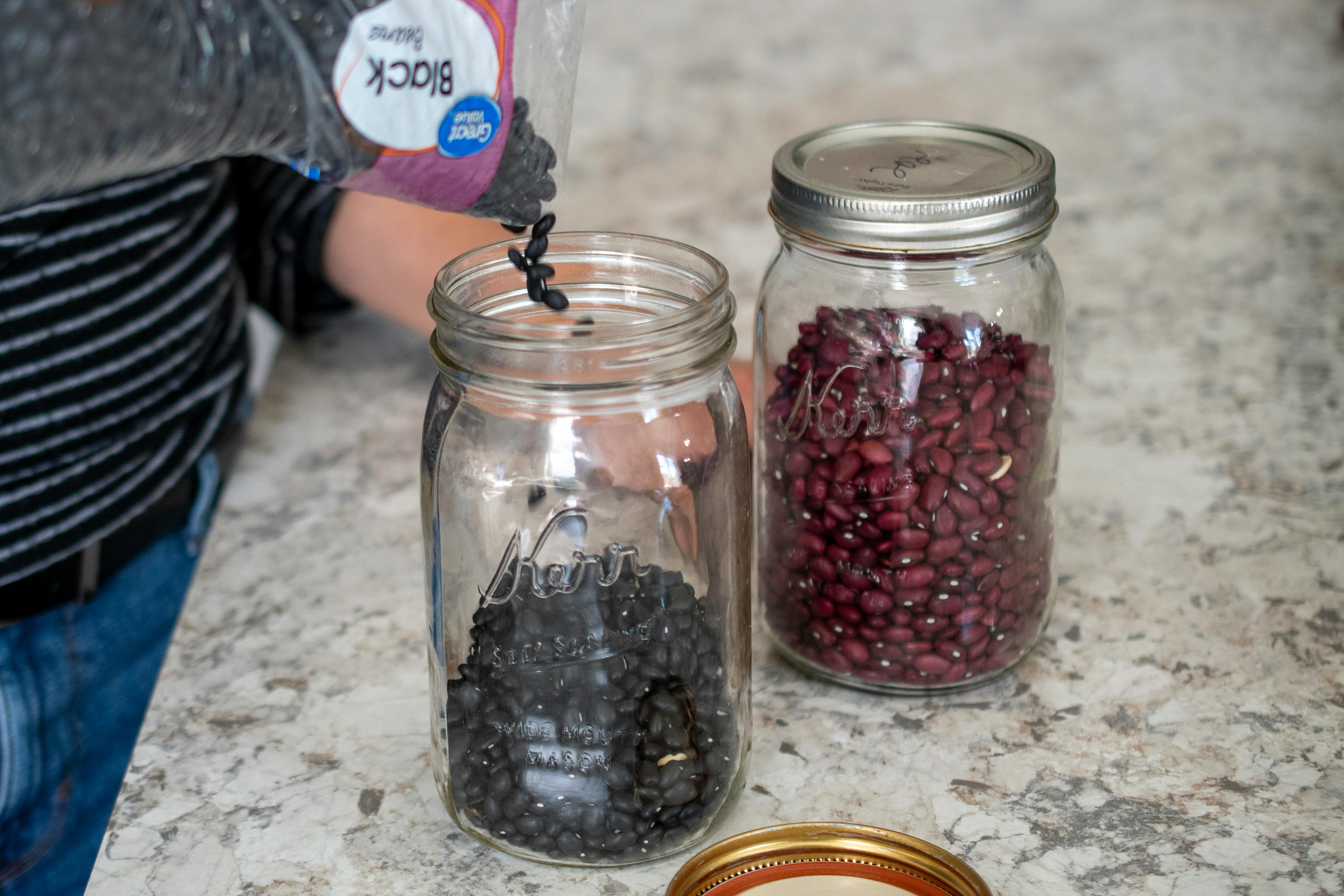 The person pouring dried beans into a mason jar