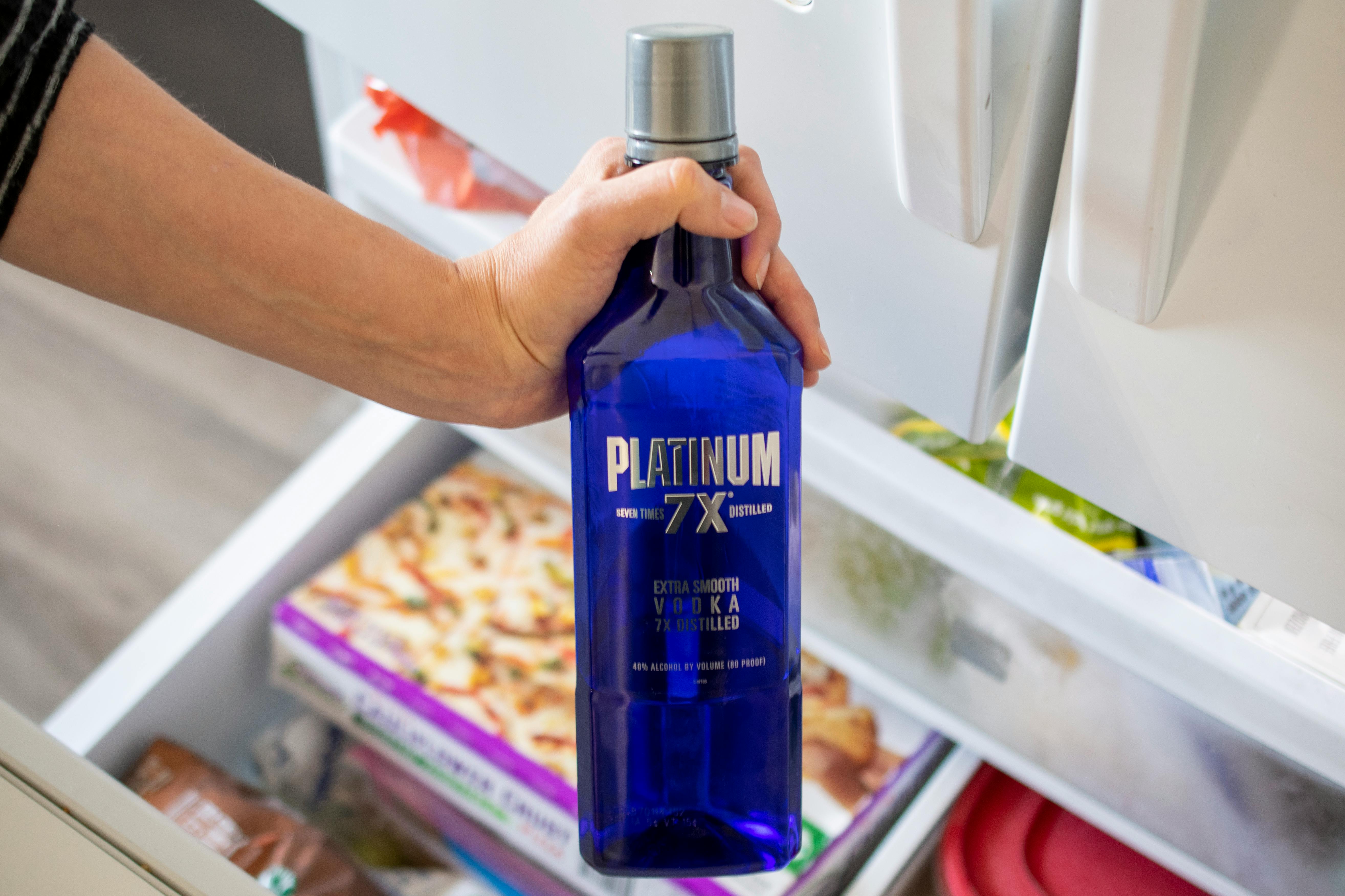 A bottle of vodka being pulled from the freezer