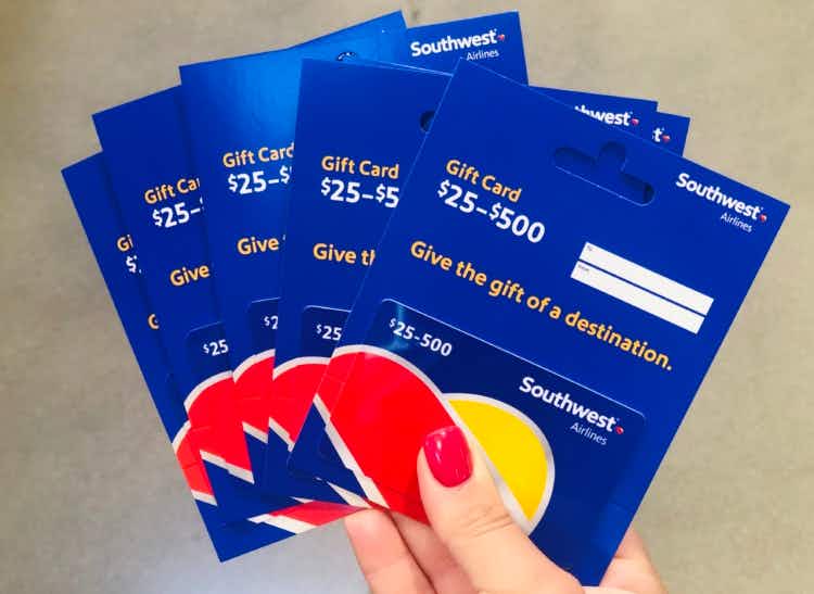 woman holding five southwest airline gift cards for $25 to $500