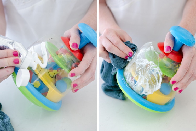 Someone removing a permanent marker stain from a child's toy with regular toothpaste.