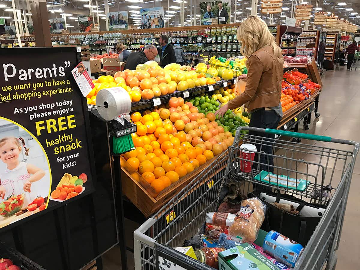 A woman shopping for produce in Fred Meyer.