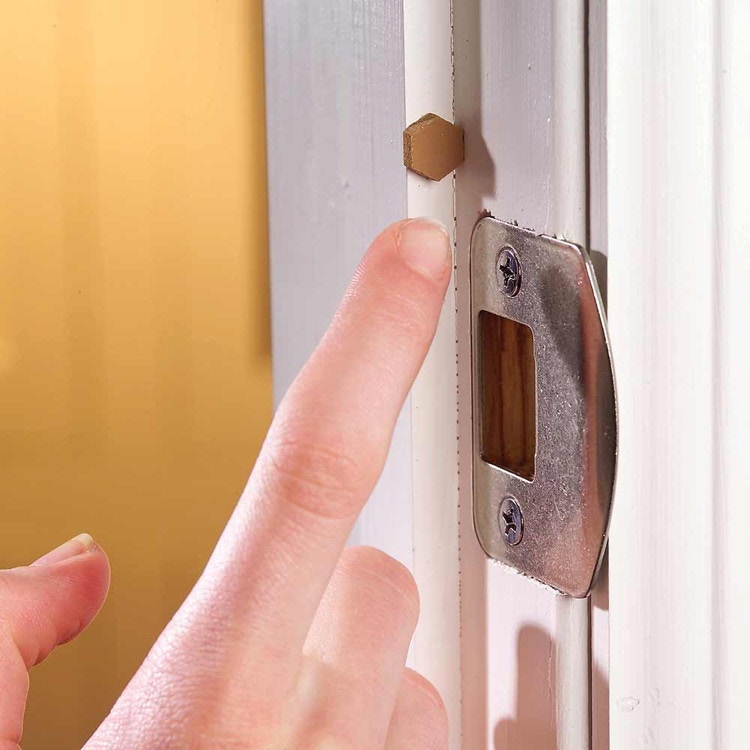 someone putting cabinet door bumper on door
