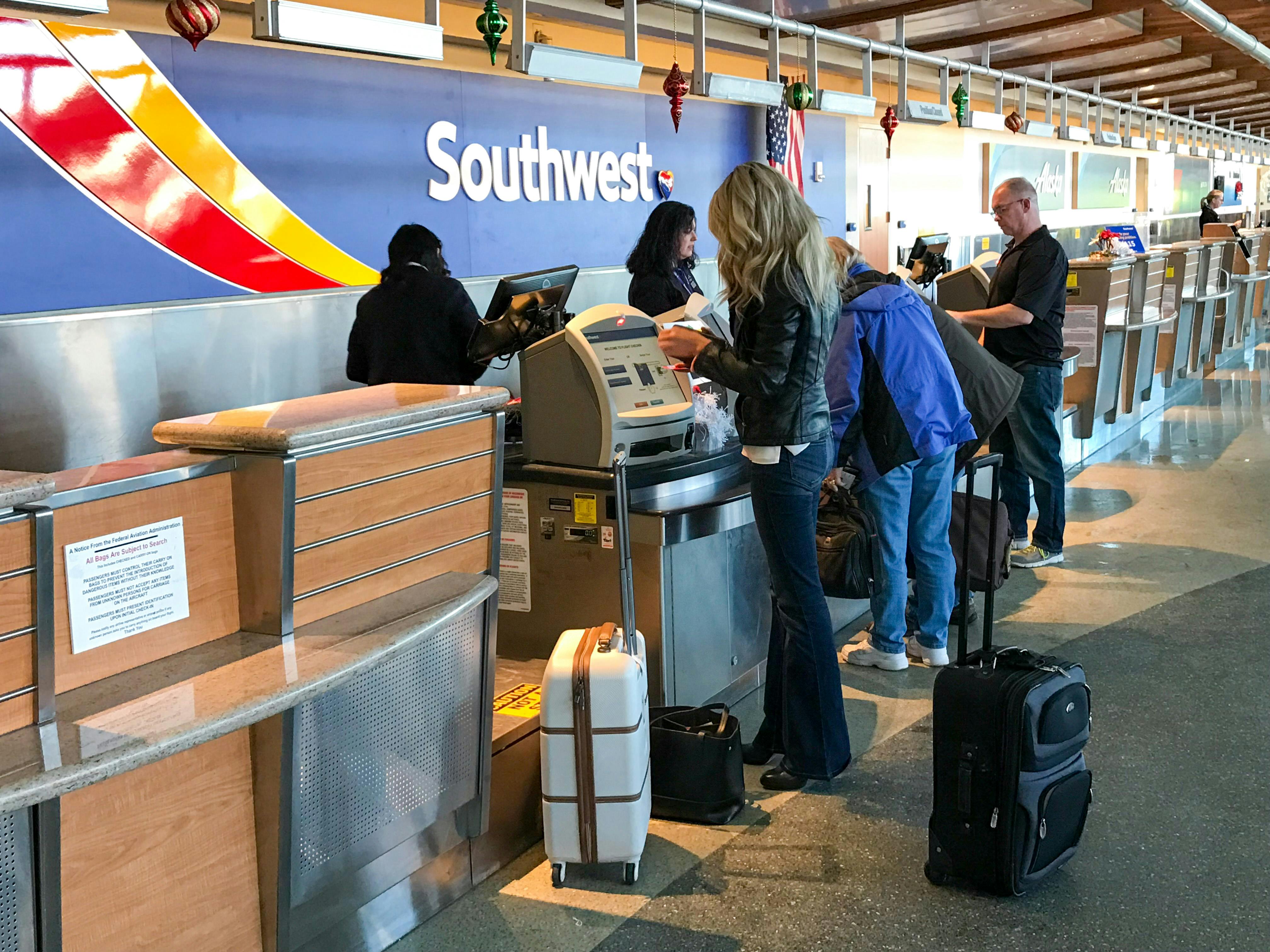 A person standing at the Southwest airlines check in desk at the airport