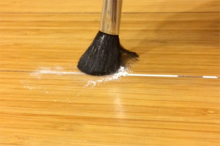 someone brushing baby powder into floor