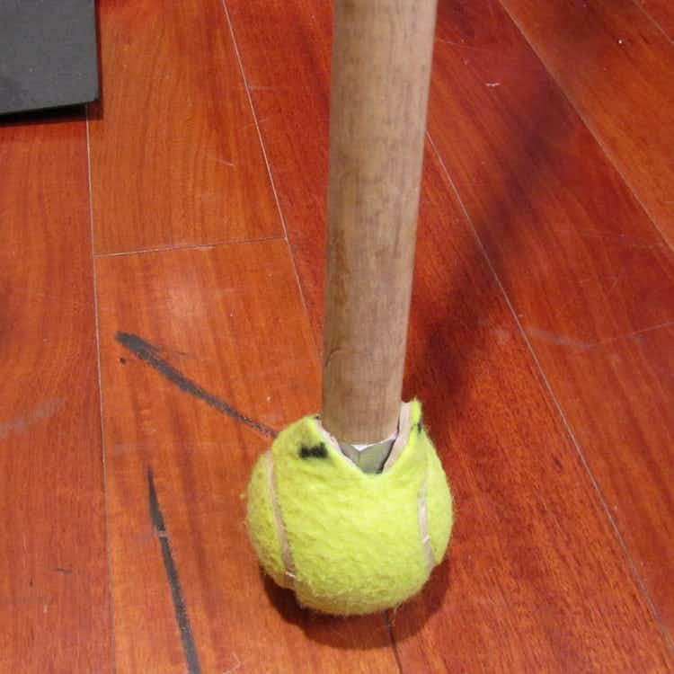 tennis ball on a broomstick on floor