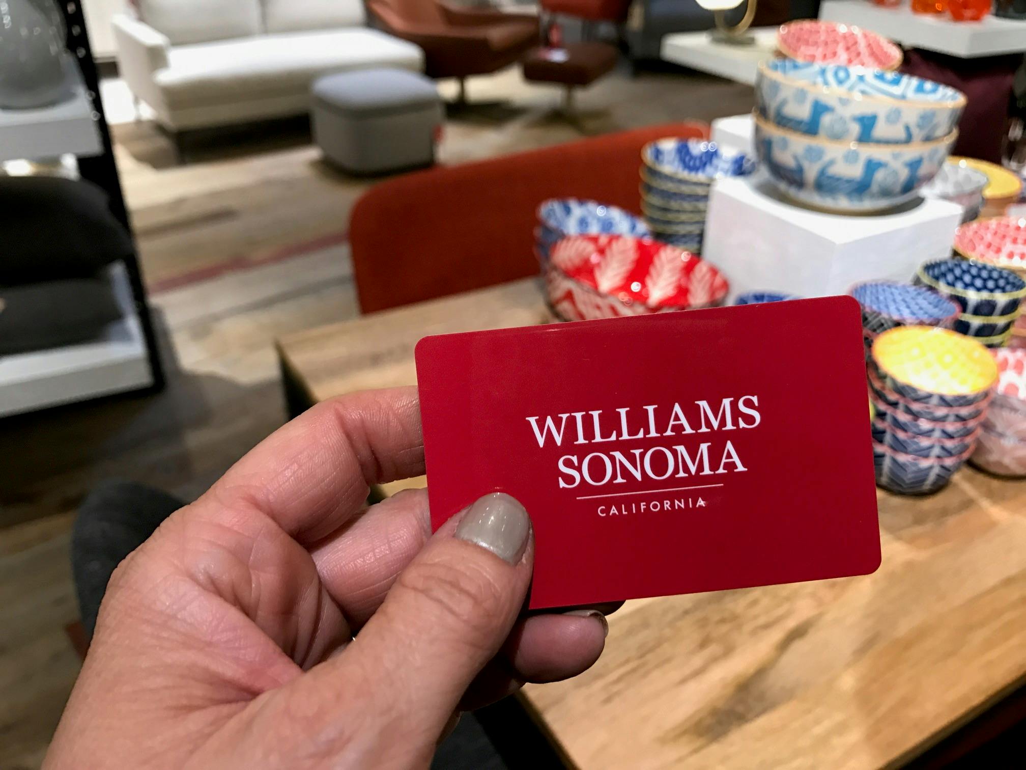 A person holding a Williams-Sonoma gift card in their hand.