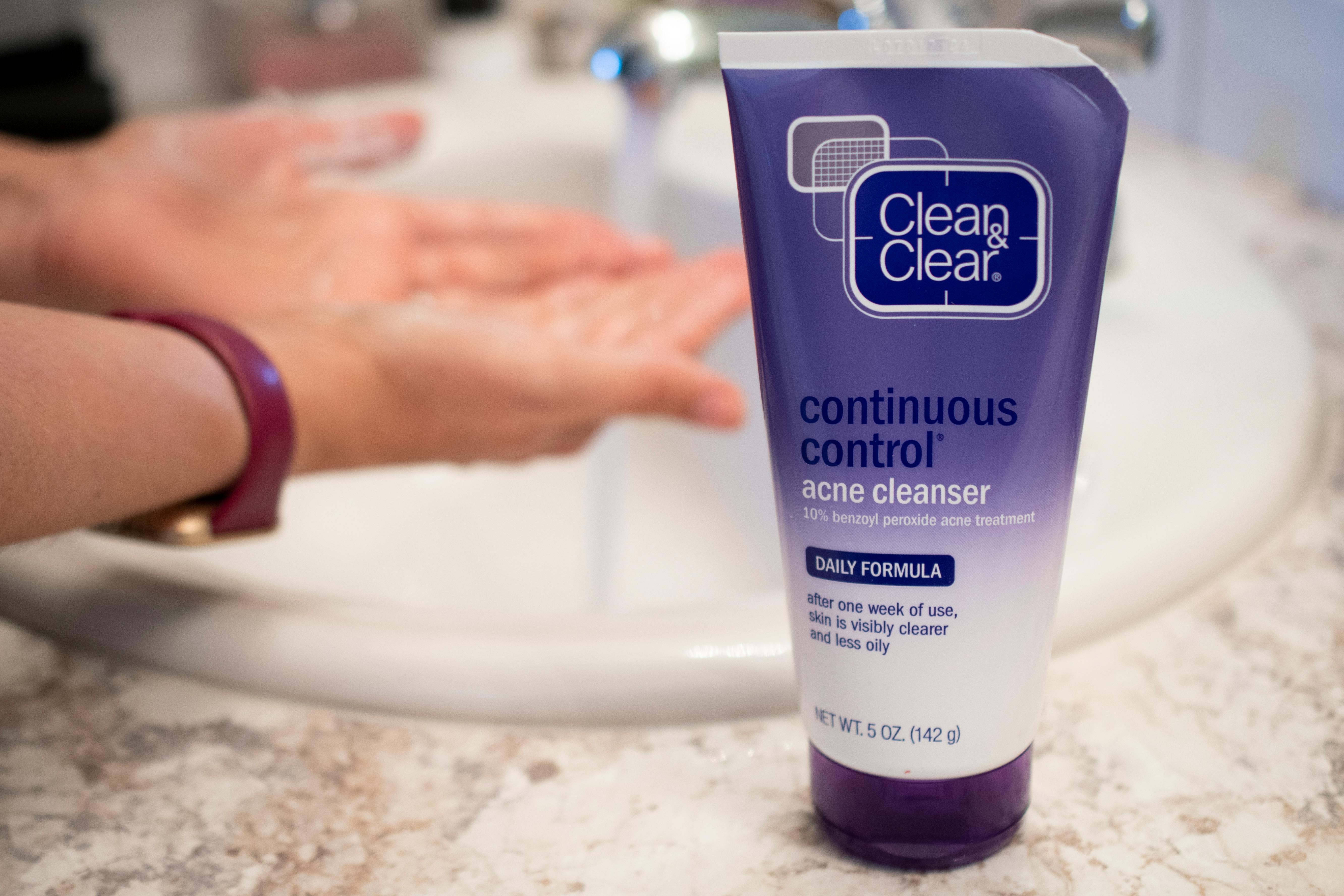 A person using Clean and Clear acne cleanser