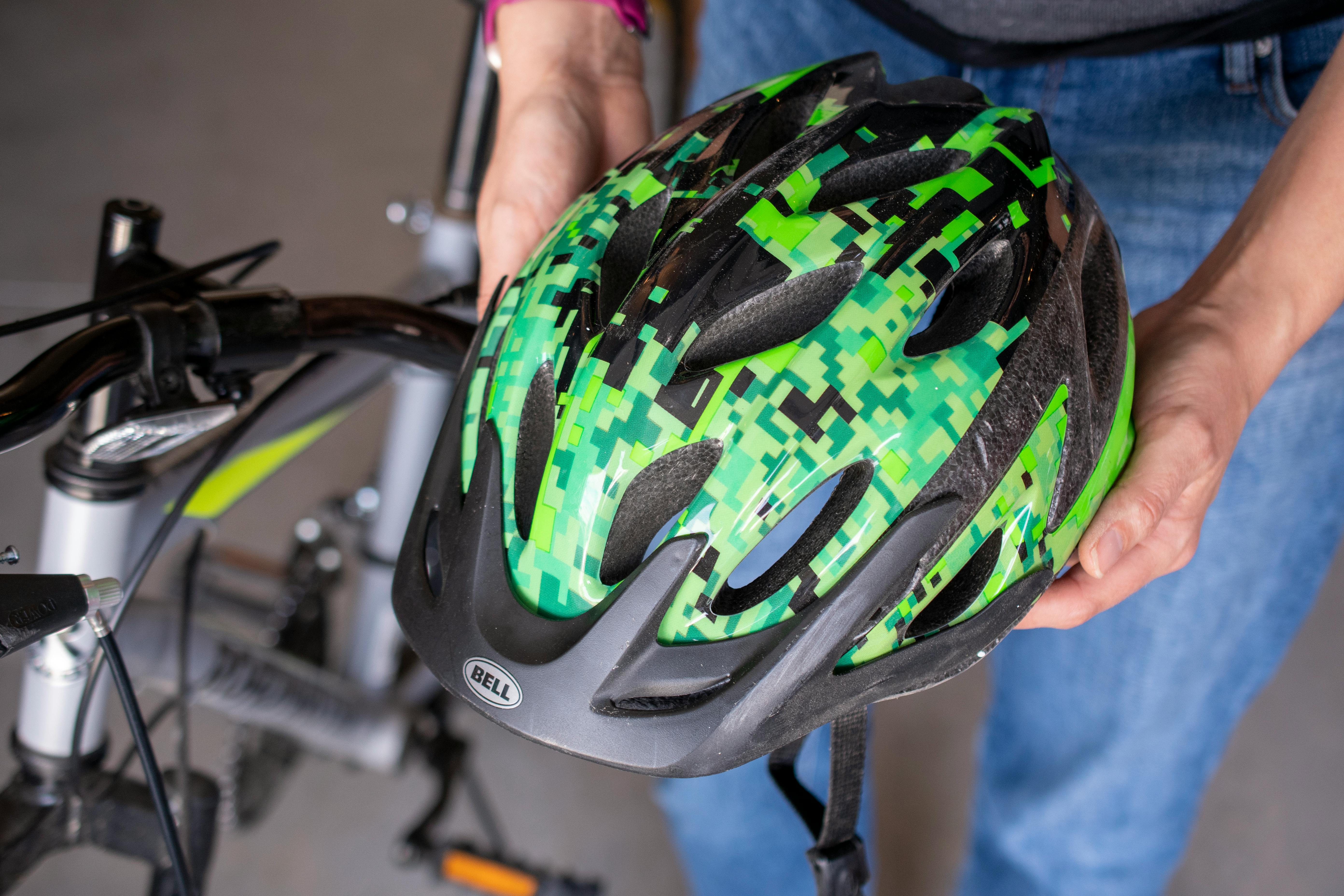 A person holding a green and black helmet