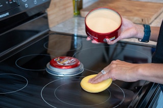 A glass cooktop stove being polished with Car Wax