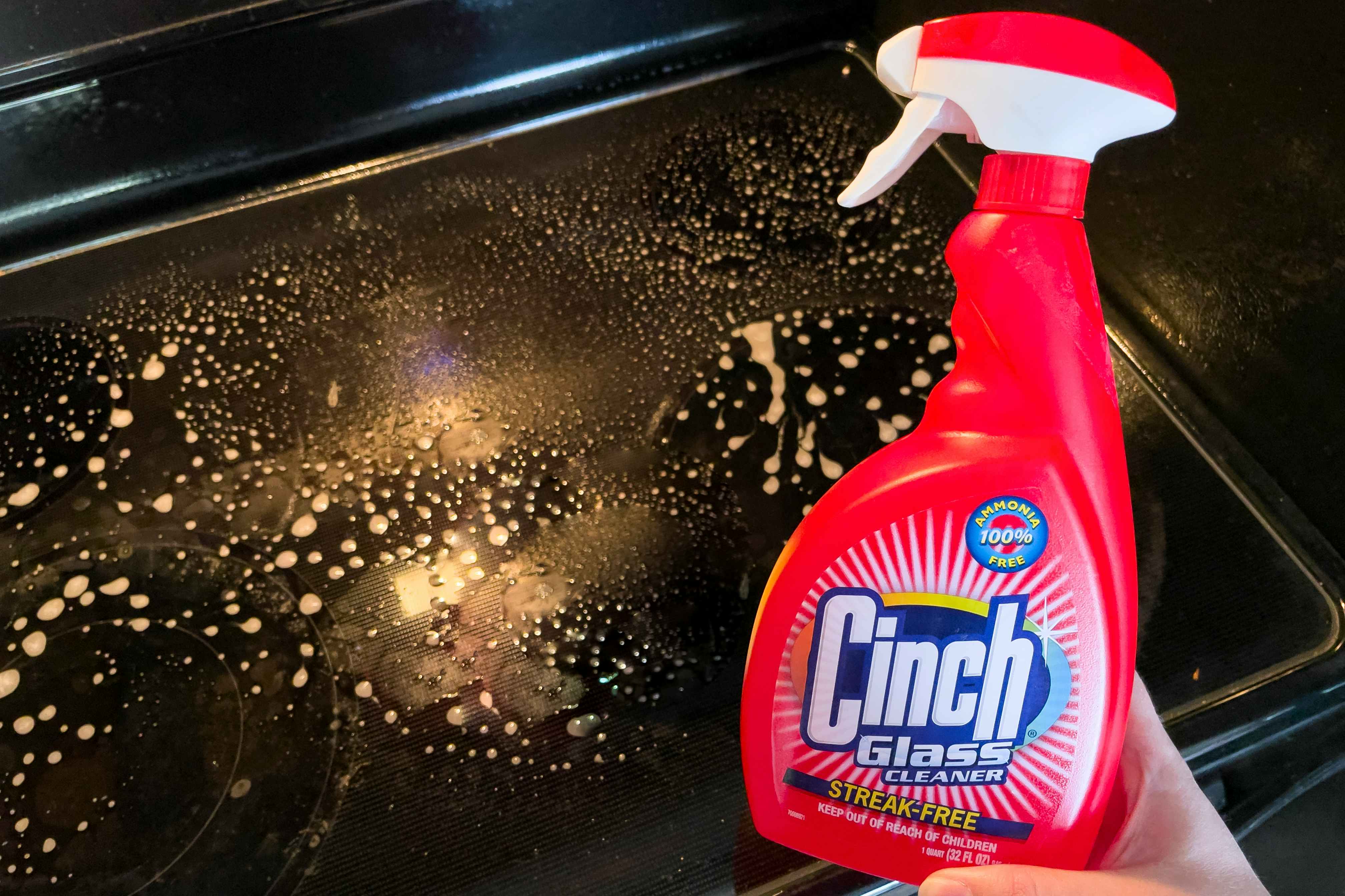 Cinch Glass cleaner held next to a glass top stove.