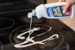 A glass cooktop stove being cleaned with Soft Scrub
