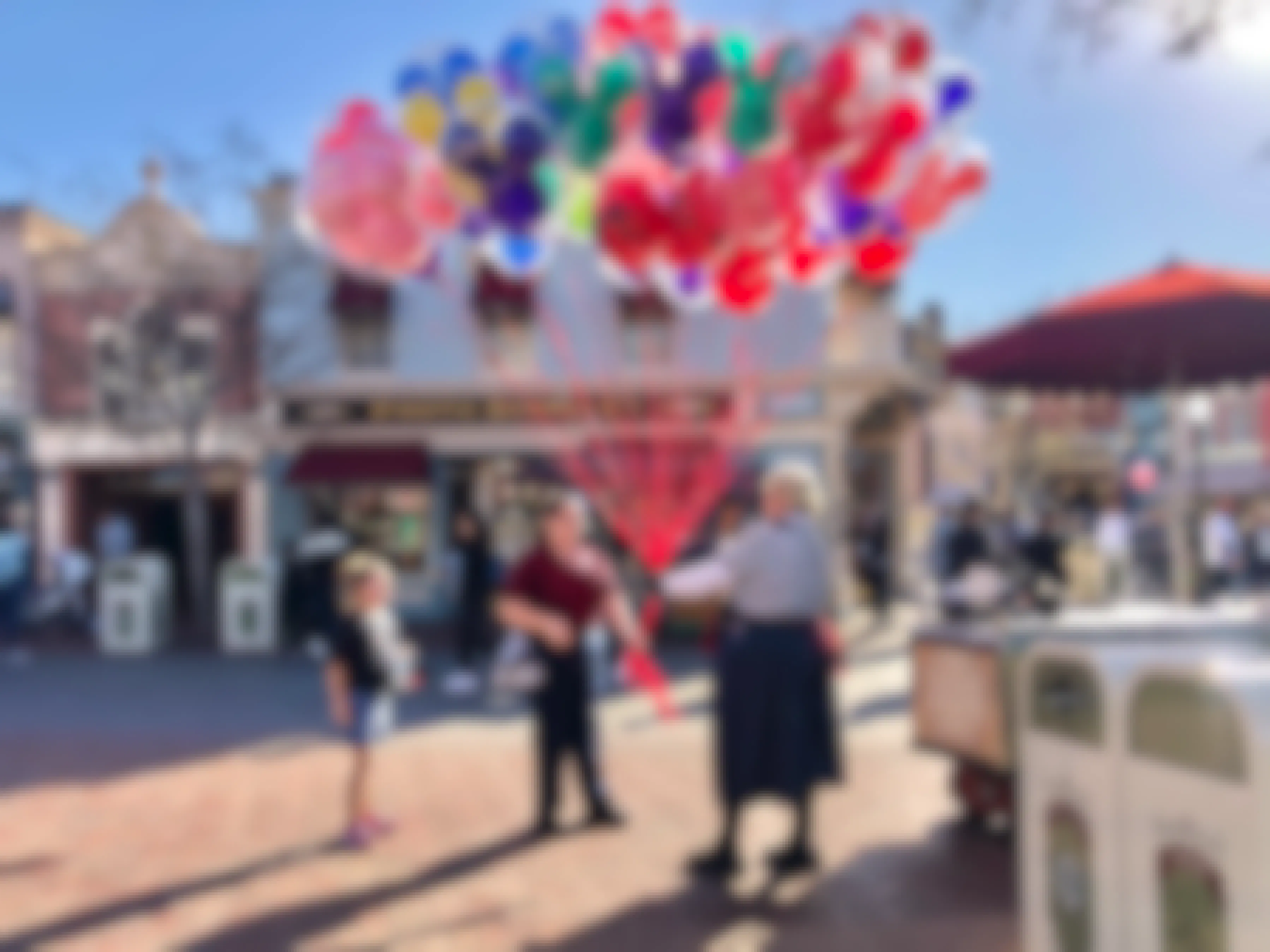 A little girl purchases balloons at Disneyland.