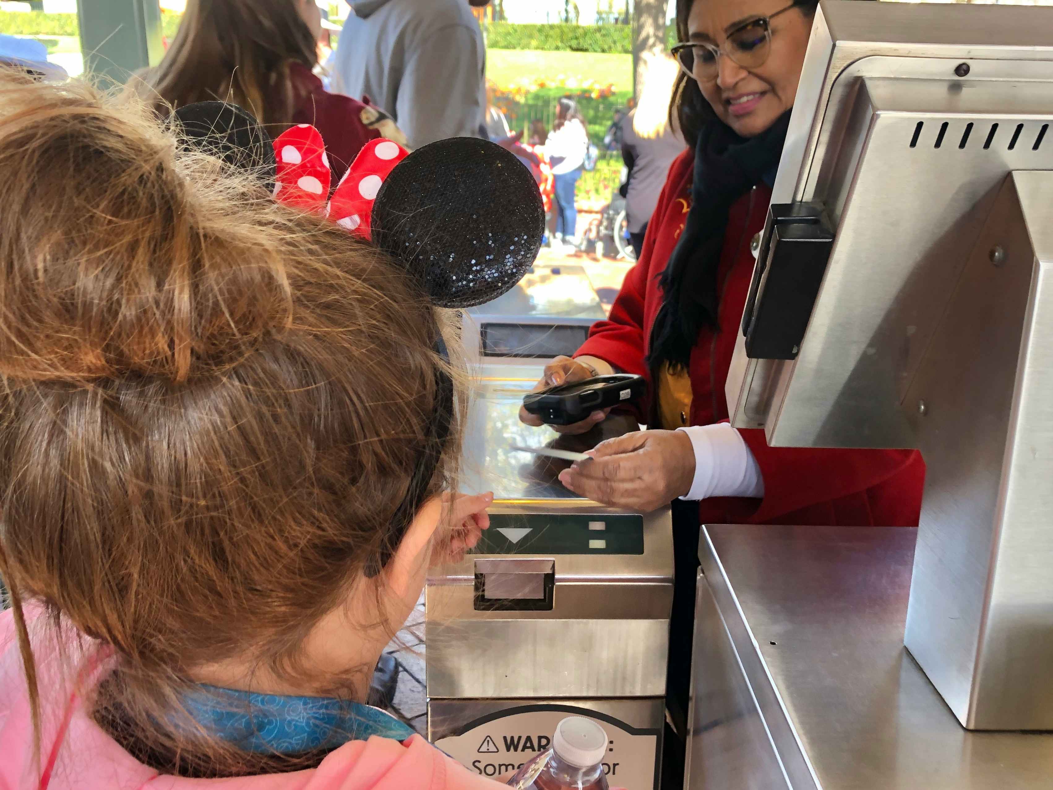 A little girl scans her ticket at the entrance of Disneyland