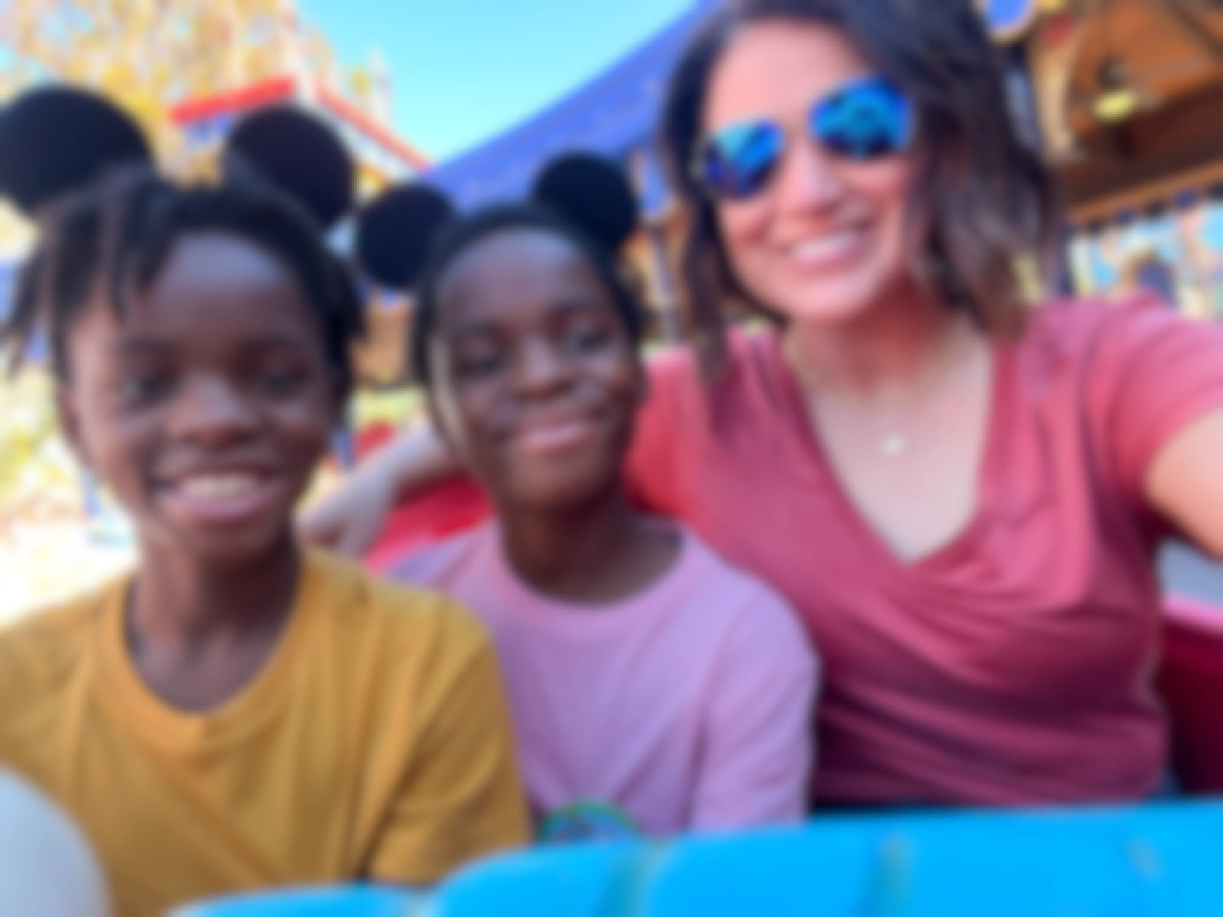 a mom and her kids riding a ride at a Disney park