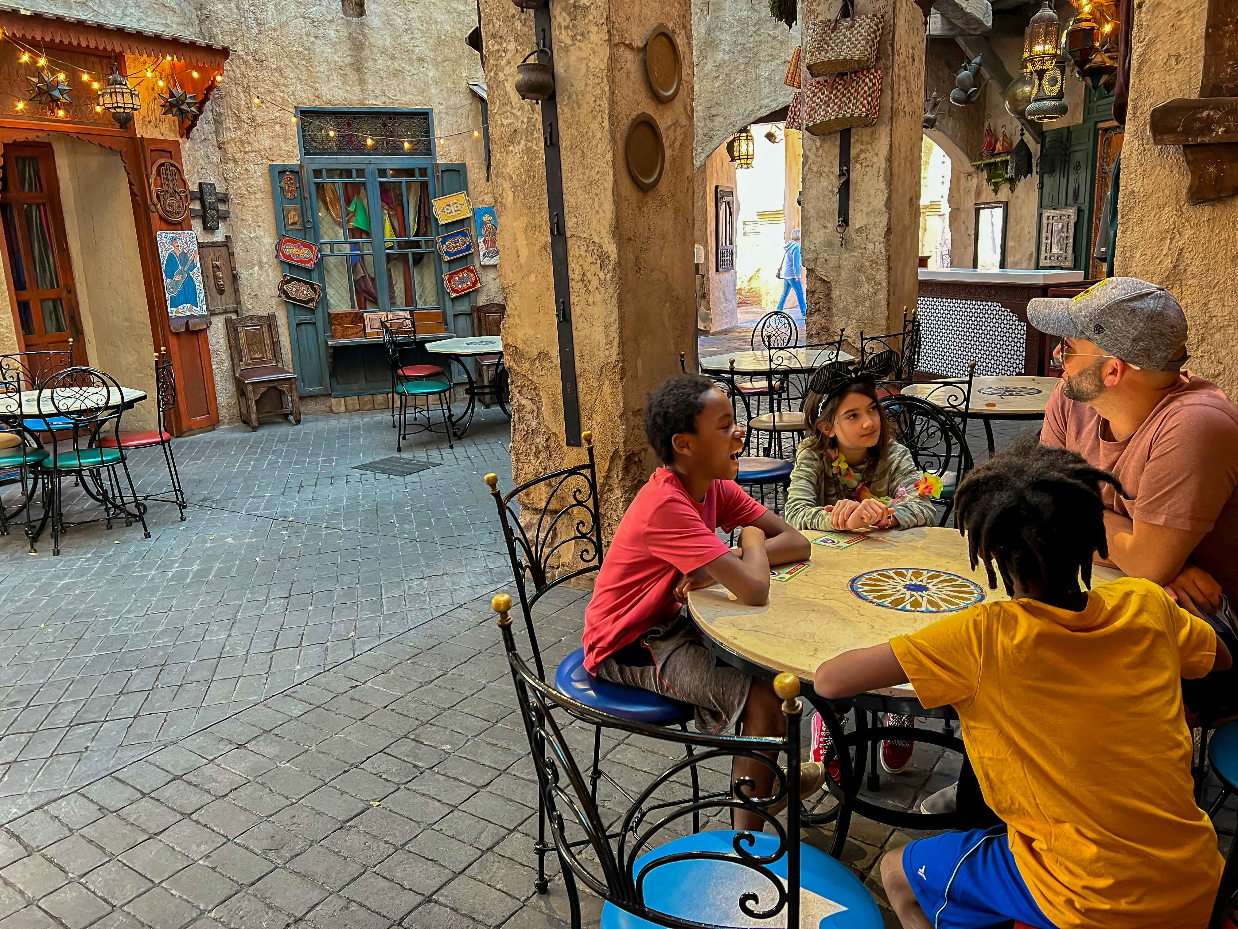 A family sitting at a table in a Disney Epcot restaurant.
