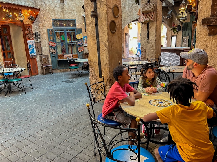 A family sitting at a table in a Disney Epcot restaurant.