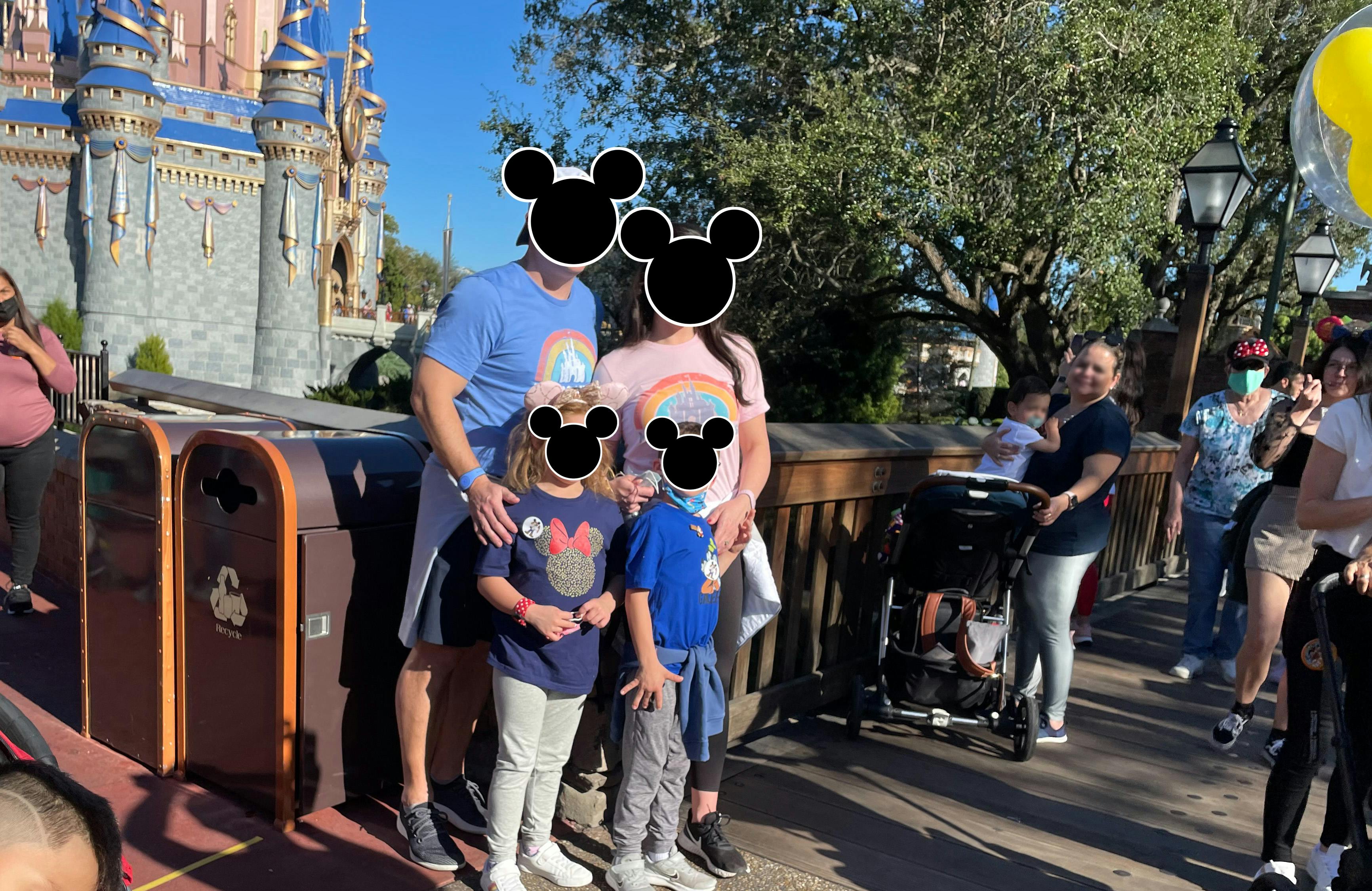 Two adults and two kids wearing Disney shirts at a Disney World park.