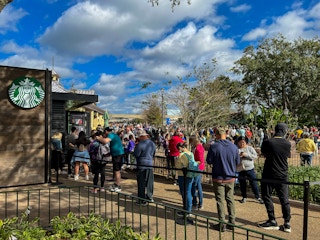 People waiting in a long line for the Starbucks inside the Disney World park.