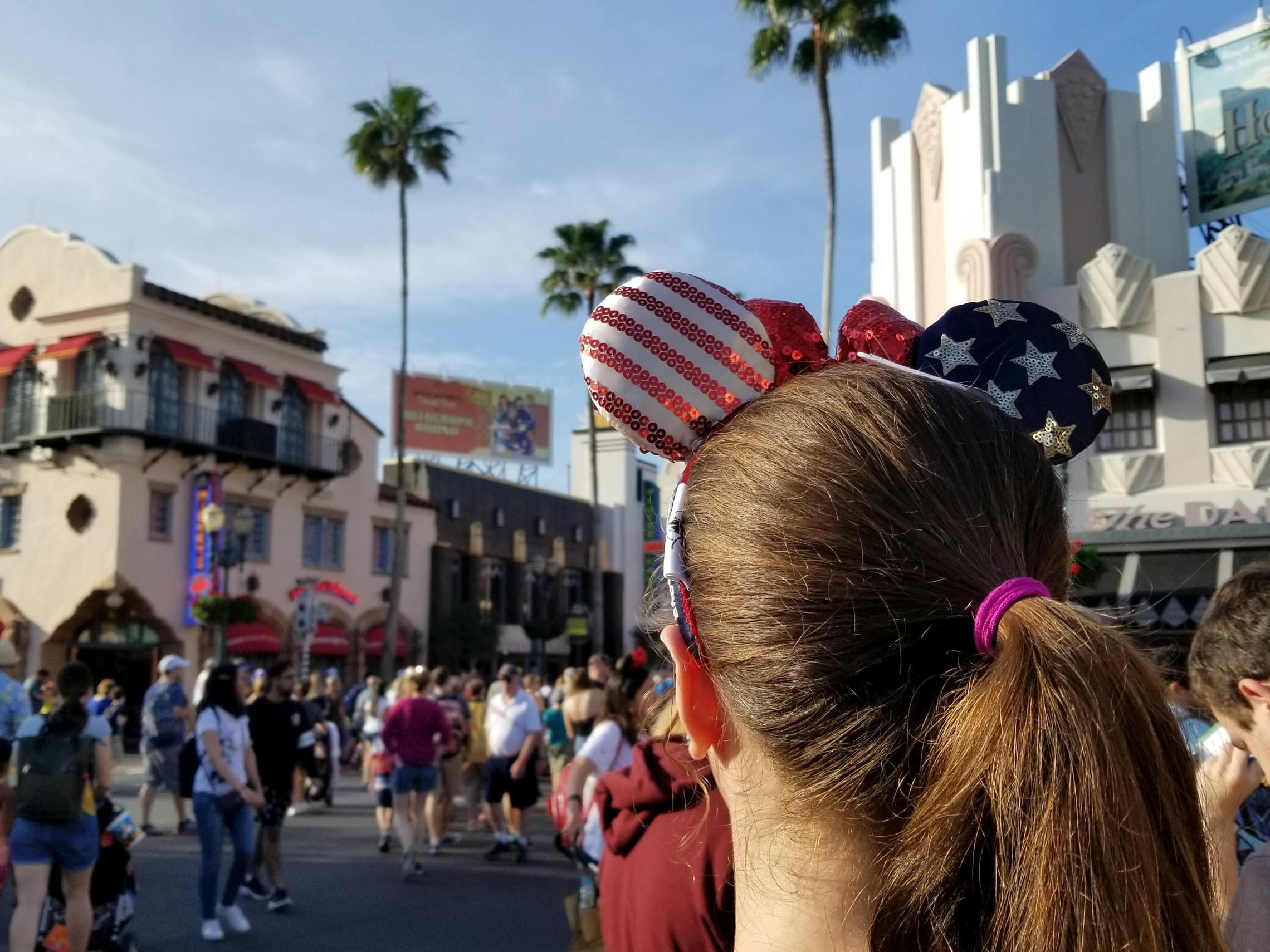 American flag printed Mickey Mouse ears on a woman in a Disney park.
