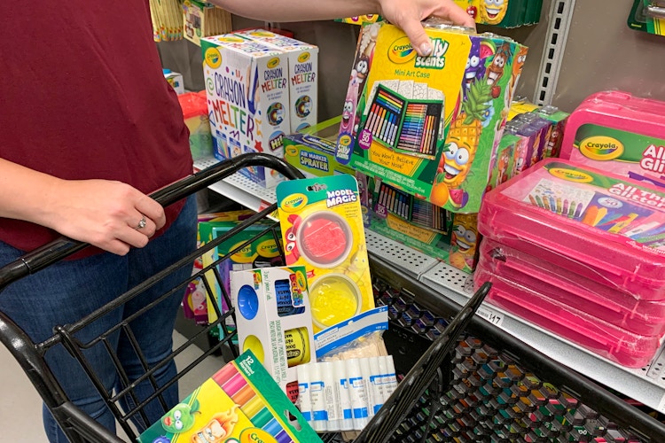 A person putting some school art supplies in a cart at Michaels.