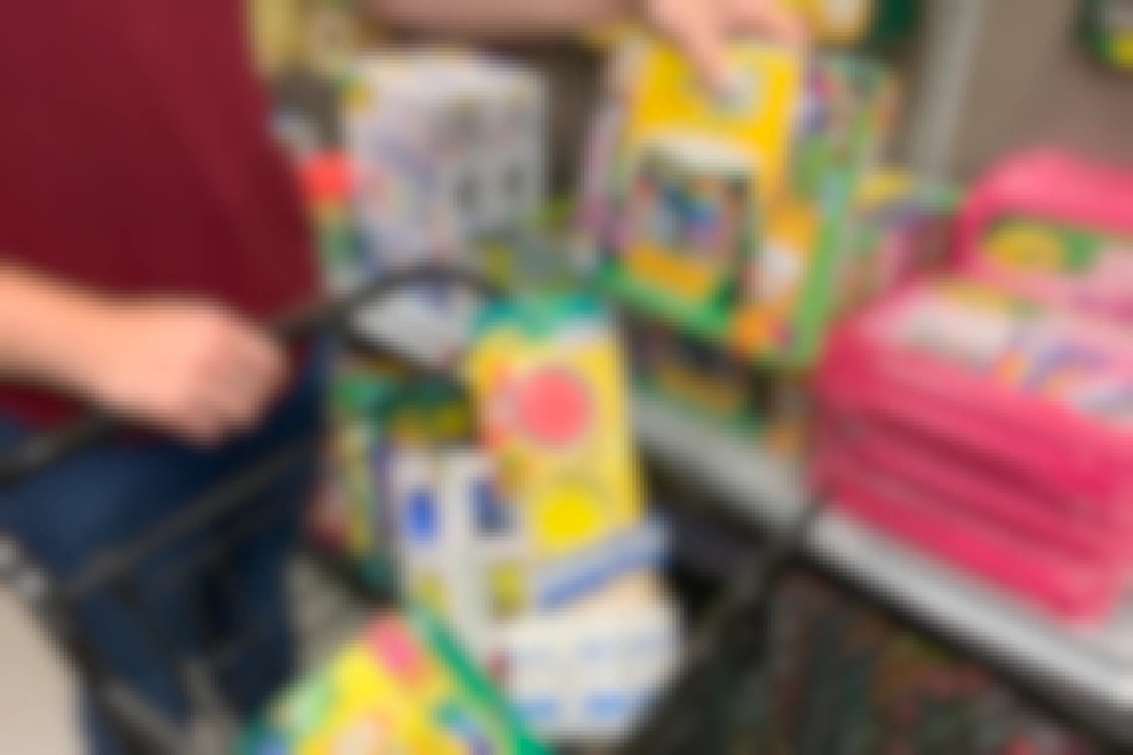 A person putting some school art supplies in a cart at Michaels.