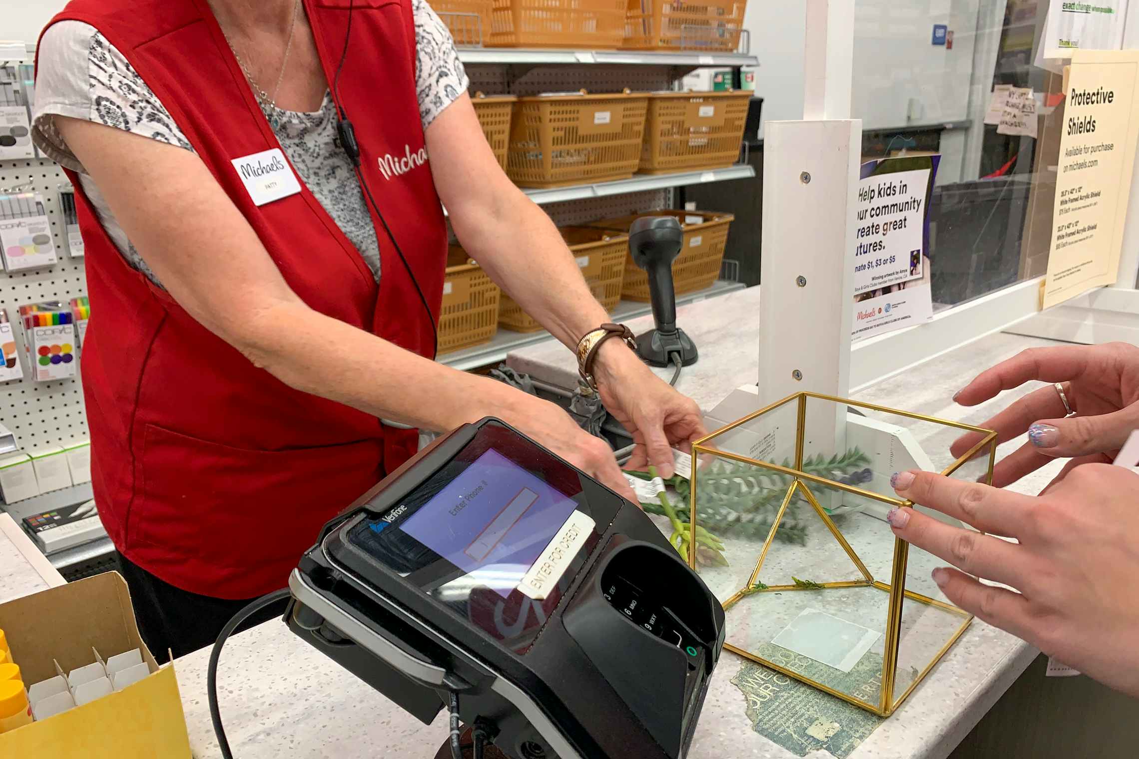 A Michaels employee ringing up purchases at the checkout.