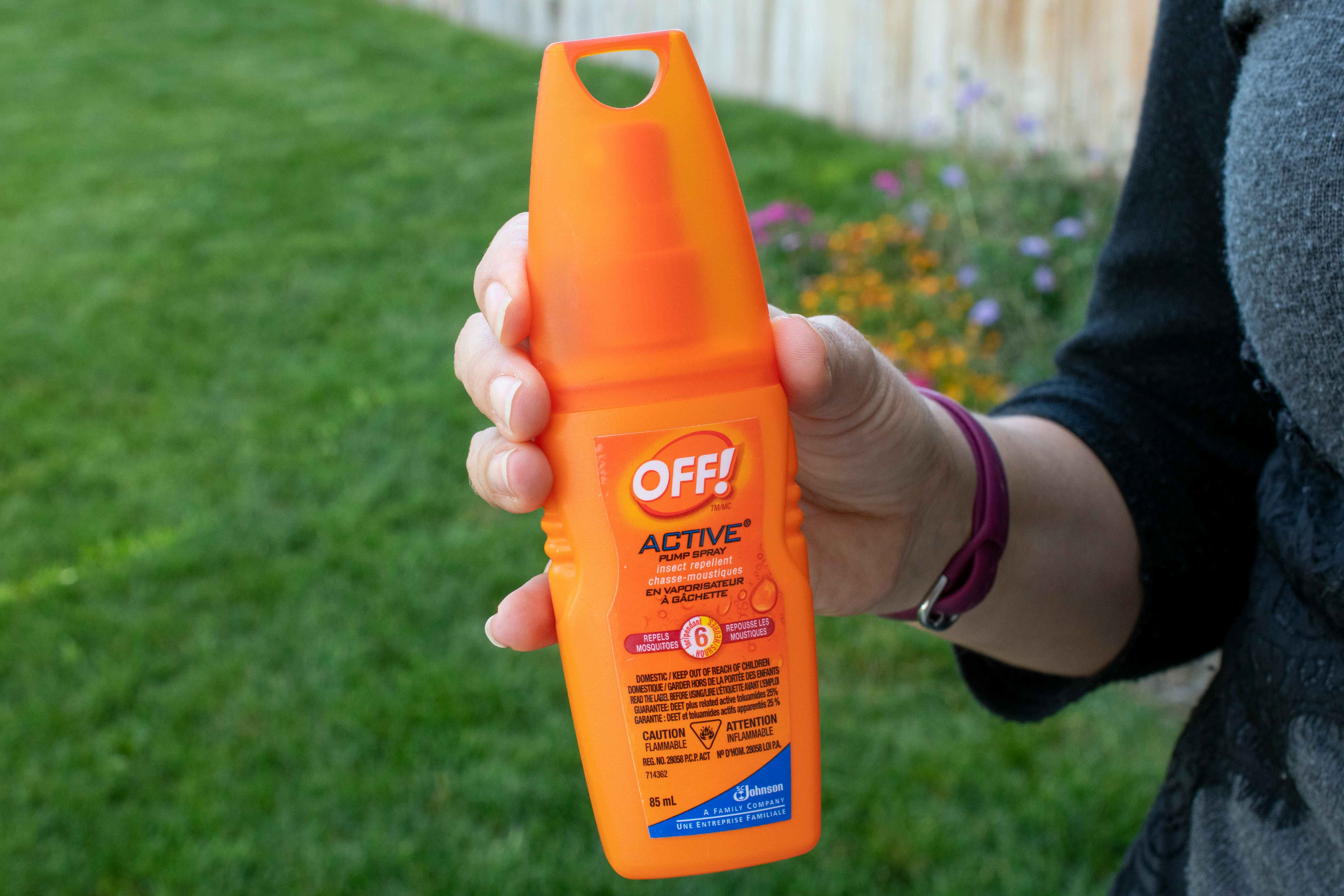 A woman holding a bottle of off insect repellent