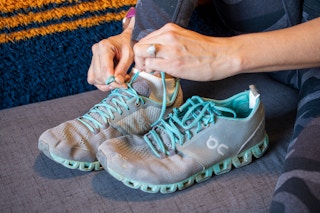 A woman tying the laces on a running shoe