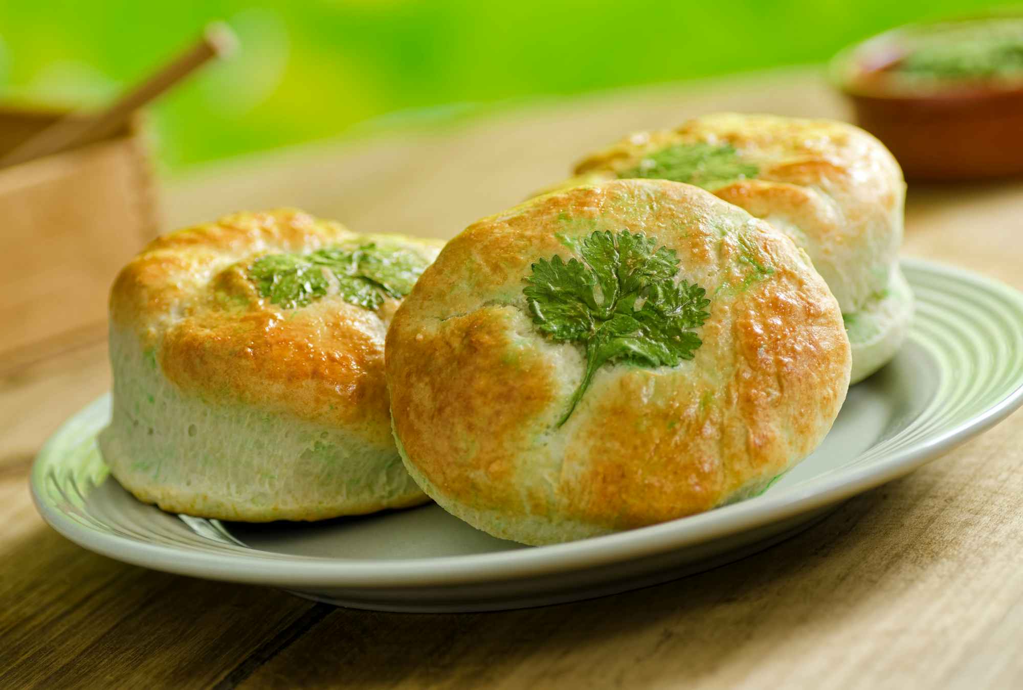 A plate of biscuits with an herb shaped like a clover baked into each one