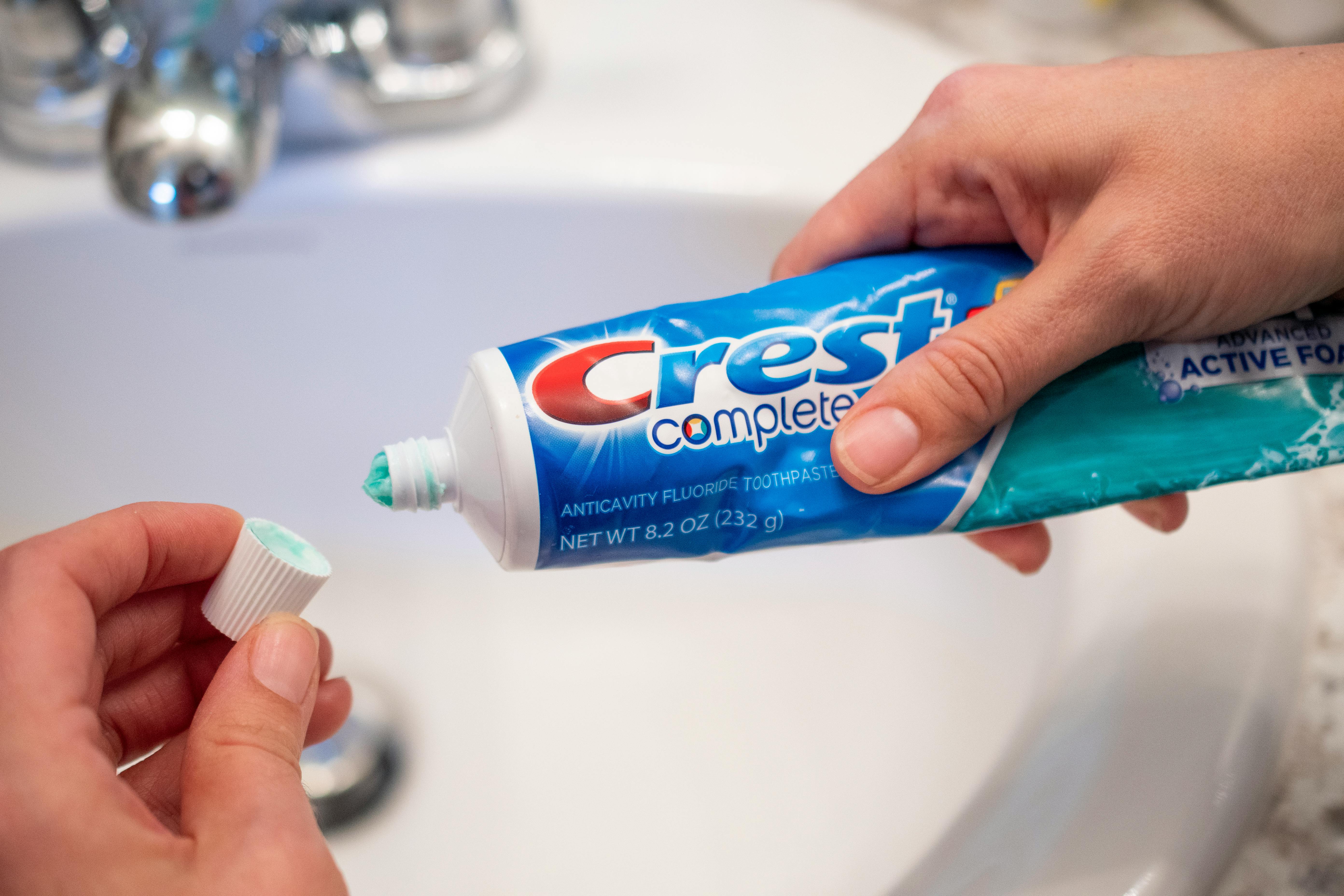 A person opening a tube of toothpaste