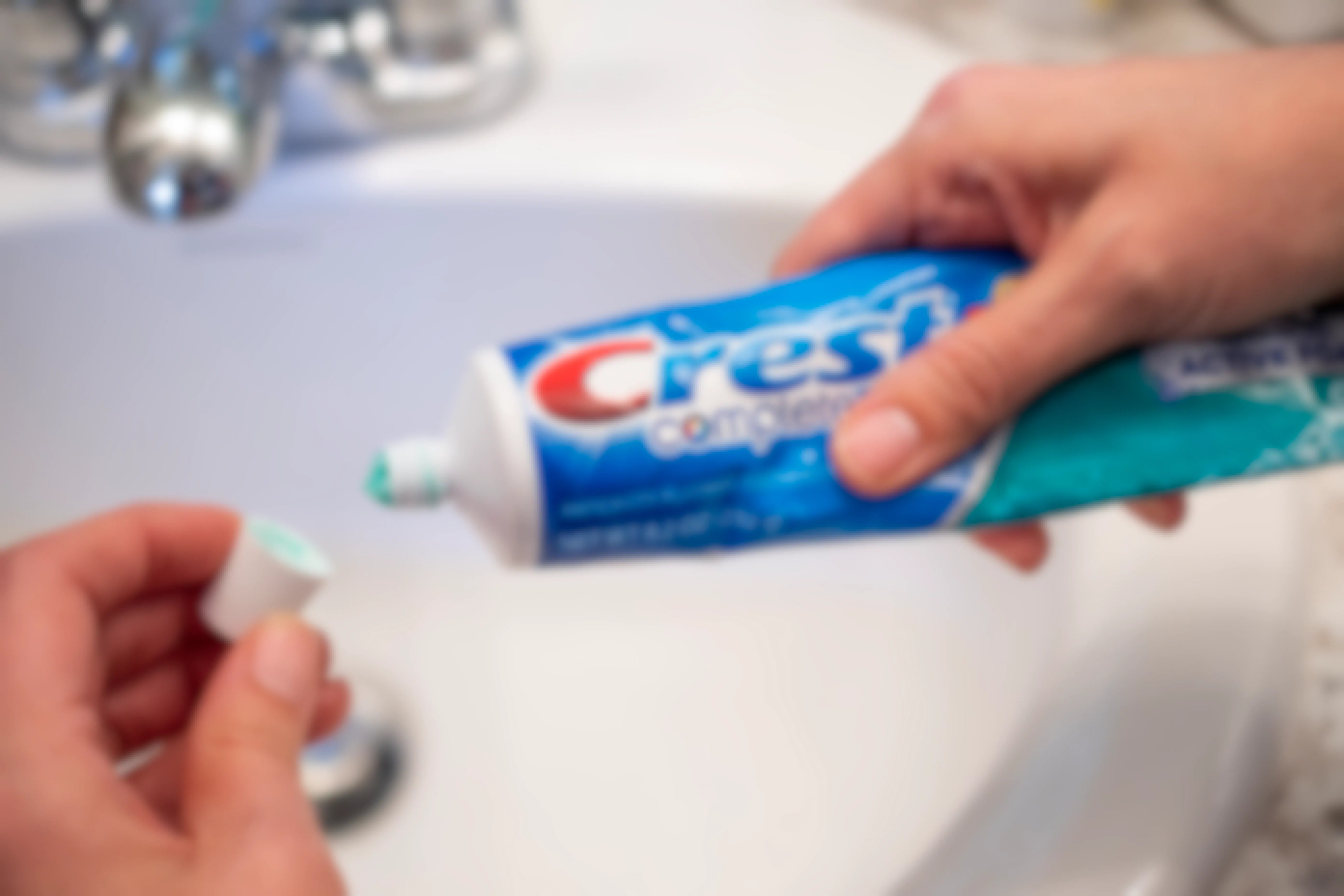 A person opening a tube of toothpaste