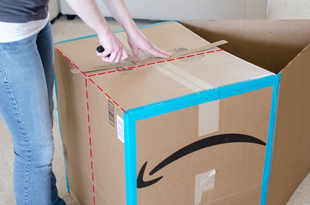 A person cutting a cardboard box.
